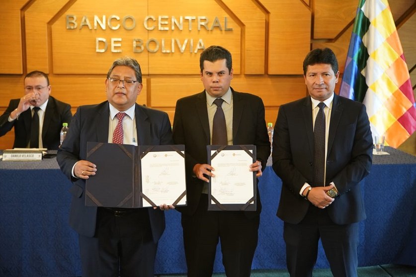 El presidente del BCB, Edwin Rojas (Izq.) y ejecutivos del Banco Unión exhiben el documento firmado