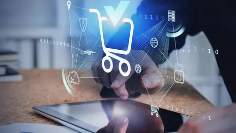Hands of man using tablet in blurry office with double exposure of futuristic online shopping interface. Concept of ecommerce. Toned image
