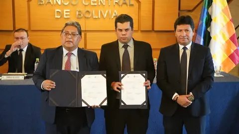El presidente del BCB, Edwin Rojas (Izq.) y ejecutivos del Banco Uni&oacute;n exhiben el documento firmado